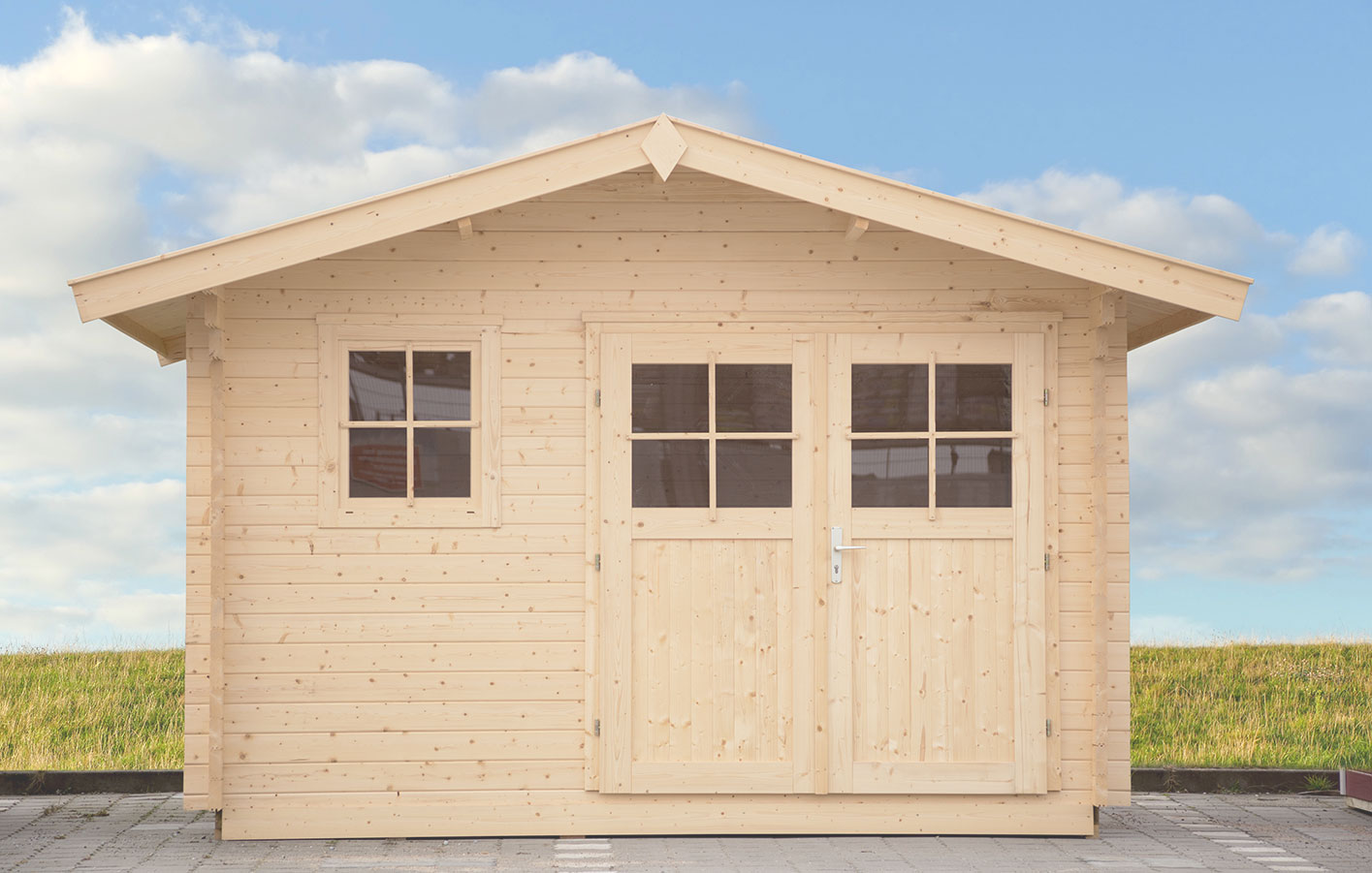 Holzgartenhaus vor Himmel und Wiese